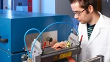 Ein Forscher des Fraunhofer IWS an einer Maschine zur Batteriefertigung.