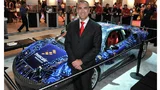 Freescales Ex-CMO Henri Richard posiert bei einem Freescale Technology Forum vor einem seiner Rennwagen.