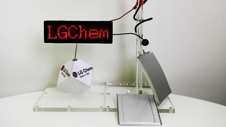 Eine weitere Demo der Akkus: der kabelförmige Akku ist um den Glasstab gewickelt und versorgt die LED-Anzeige. In der Mitte der Akku mit der Stufe, die hier gut zu sehen ist. Ganz rechts der biegbare Akku.