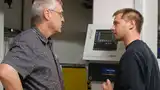Klein, unauffällig, aber leistungsstark: die Steuerzentrale der Sembach-Kompressoren: Thomas Wehmer (li.), Integriertes Management, und Mathias Norgall, Leitung Automation & Instandhaltung, vor dem Panel der Druckluftanlage.