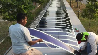 Organische Solarfolie wird auf dem überdachten Gehweg nahe des Militärflughafens in Singapur installiert.