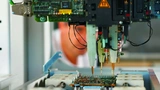 Bild 2. Die Steuereinheit wird hier mit einem Flying-Probe-Tester auf hundertprozentige Funktionsfähigkeit getestet.
