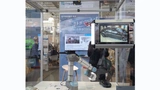 Bild 3. Funktionsfähiger Prototyp: Das Bild auf dem Display wird von der Dome-Kamera am Fertigungsroboter aufgenommen und über die VLC-Box am Gelenk an die schwarze Empfängerbox unter der Decke übertragen und von dort zum Display gesendet.