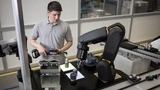 Mensch und Roboter Hand-in-Hand. Die Apas-Workstation von der Robert Bosch GmbH ist ein teilautomatisierter Handarbeitsplatz, mit dem die Fehlerrate bei Handarbeiten weiter reduziert werden soll