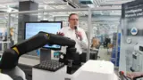 Im APAS-Showroom: Wolfgang Pomrehn, Produktmanager der APAS-Familie von Bosch, stellt die drei Modelle der Produktfamilie vor. Der Roboterarm »Assistant« stand bereits auf der Automatica 2016 im Mittelpunkt, daher wird auf der Vision die meiste Aufme