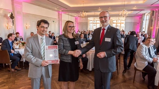 Peter Spevak (links) und Corrine Zeller (Mitte), beide Texas Instruments, mit Urkunde für den dritten Preis in der KAtegorie Aktive Bauelemente, Harry Schubert (rechts), Elektronik
