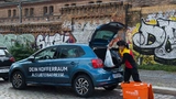 Kofferraum wird vom Zusteller beladen.