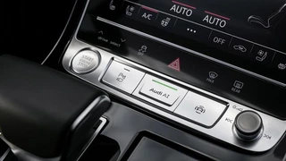 Der Fahrer aktiviert den Staupilot mit der AI-Taste auf der Mittelkonsole.