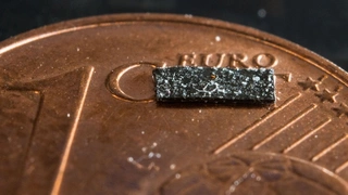 Ein Miniroboter liegt in einem Labor im Max-Planck-Institut für Intelligente Systeme auf einem Cent-Stück.