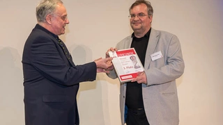 Elektronik-Redakteur Alfred Goldbacher beglückwünscht Wolf-Dieter Roth, der stellvertretend für den Distributor Hy-Power Power Components die Urkunde für den Drittplatzierten Maxwell Technologies entgegennahm.