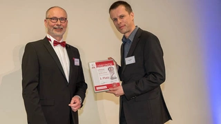 Uwe Wahl von Infineon Technologies (rechts) mit Urkunde zum 3. Preis der Kategorie »Aktive Bauelemente«, Harry Schubert, Redakteur der Elektronik (links).