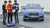 Entwickler mit Modellauto neben Audi Q2