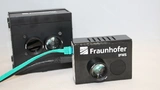 Der alte Li-Fi-HotSpot (hinten) und der neue: Mit Abmessungen von 67 mm x 69 mm x 34 mm deutlich kleiner.