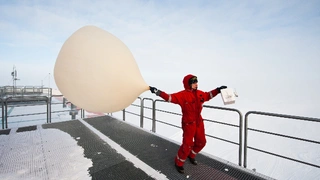 Meteorologe Thomas Schmidt laesst bei starkem Wind einen Wetterballon vom Dach der deutschen Antarktis-Forschungsstation Neumayer-Station III steigen