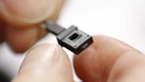 In präziser Handarbeit werden die 12 oder 24 Faserenden in den MPO-Stecker eingeführt.
