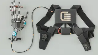 Aufbau des Systems: Der batteriebetriebene Motor im Rucksack bewegt die Finger des Exoskeletts über einen Bowdenzug. Für die bestmögliche Kraftübertragung sorgen 3D-gedruckte Fingerglieder aus Hochleistungskunststoff von Igus.
