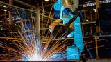 Ein Roboter schweißt ein Bauteil in einer Fabrik
