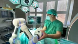 Prof. Dr. med. Matthias Kirsch testet im OP-Saal den Roboterarm Cirq - es ist ein dem menschlichen Arm nachempfundener tragbarer OP-Roboter.