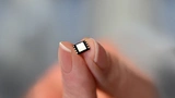 Größenvergleich einer eSIM mit zwei Fingern