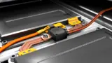 Auf einer Stromschiene montiertes CSM Open-Shuntmodul HV SBM_I open zwischen zwei Batteriemodulen einer Hochvolt-Batterie.
