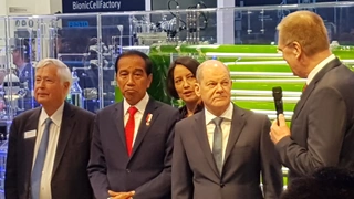 Bundeskanzler Olaf Scholz, Festo-Vorstandsvorsitzender Dr. h.c. Oliver D. Jung (mit Mikrofon), der indonesische Staatspräsident Joko Widodo und Festo-Gesellschafter Dr. Wilfried Stoll.