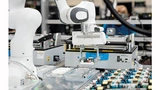 Der Cobot von TQ-Systems/Franka Emika bei der Arbeit – mit einer elektronischen Baugruppe im Zangengriff
