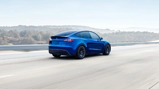 Blauer Tesla Model Y auf der Straße.