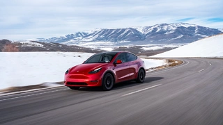 Roter Tesla Model Y in den Bergen.