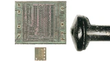 Zwei EEPROM-Dies im Vergleich zu einem Stecknadelknopf