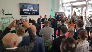 Bundesfinanzminister Christian Lindner (hinten Mitte) durchschneidet gemeinsam mit RobCo-CEO Roman Hölzl und Investor Frank Thelen symbolisch das Band zur Eröffnung des neuen Firmensitzes von RobCo.
