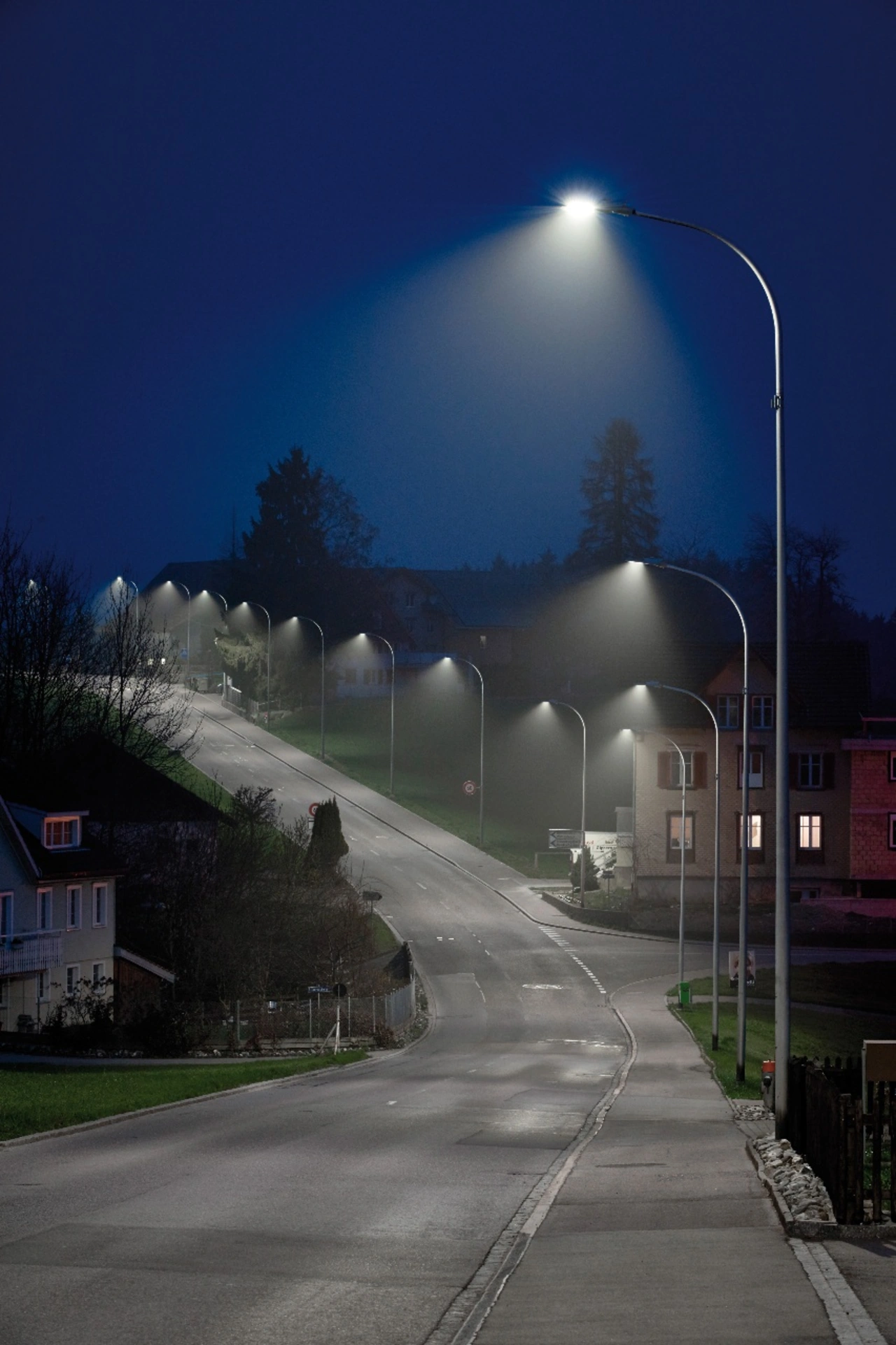 Beleuchtete Dorfstraße mit Straßenlaternen  Beleuchtete Dorfstraße mit Straßenlaternen